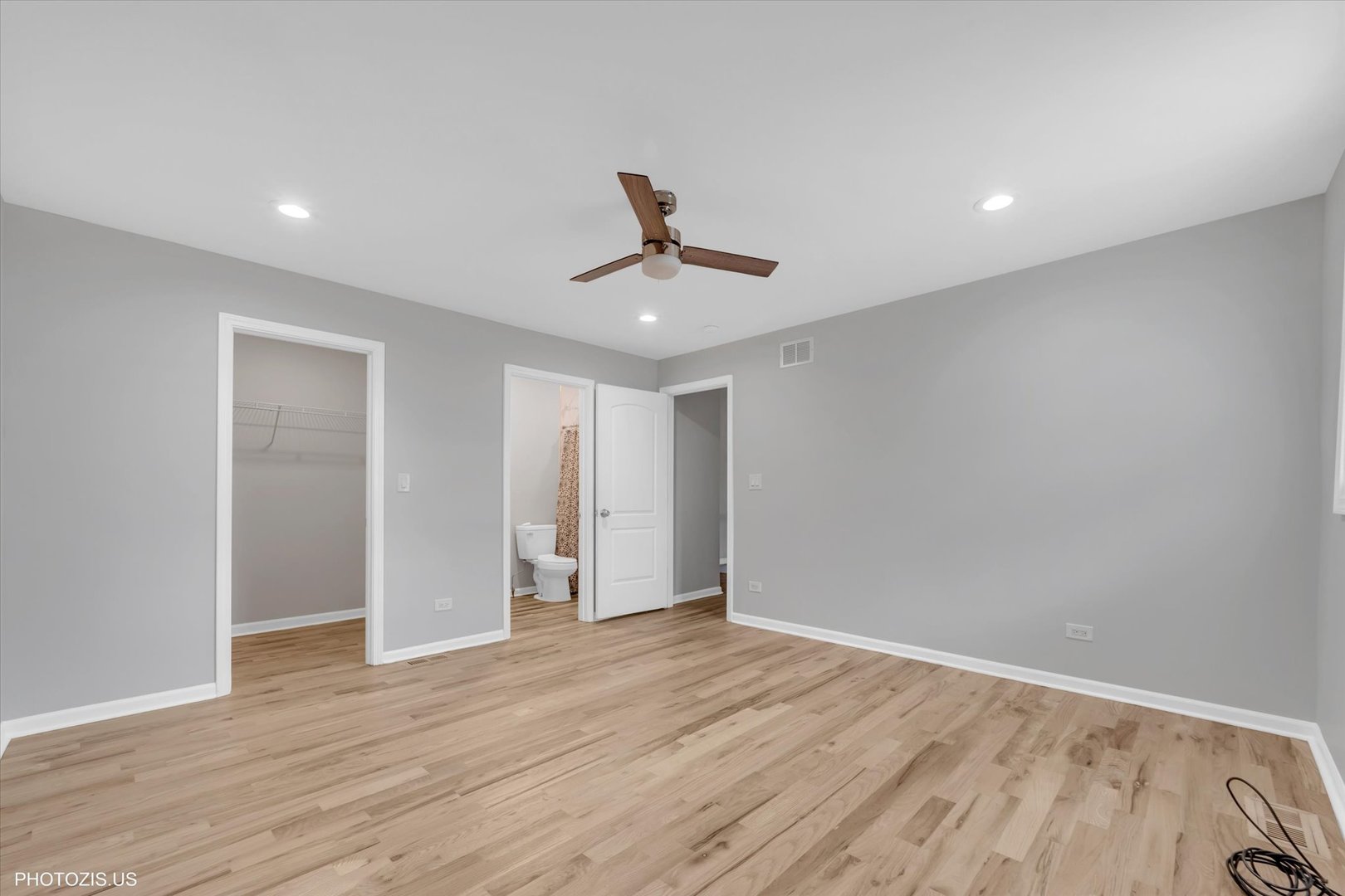 8404 South Exchange Avenue Chicago, IL 60617 - Photo 36 of 48 a view of a room with wooden floor and a ceiling fan