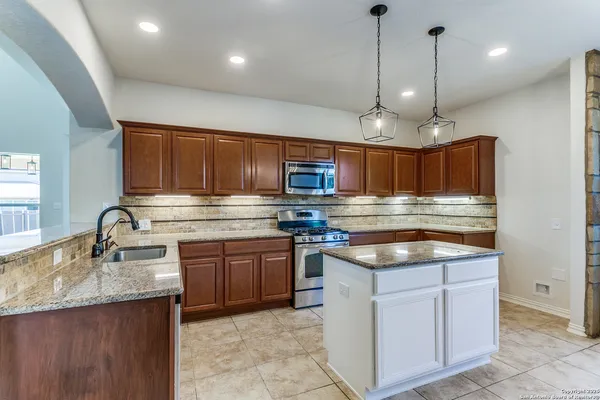 a kitchen with stainless steel appliances granite countertop a sink and a stove