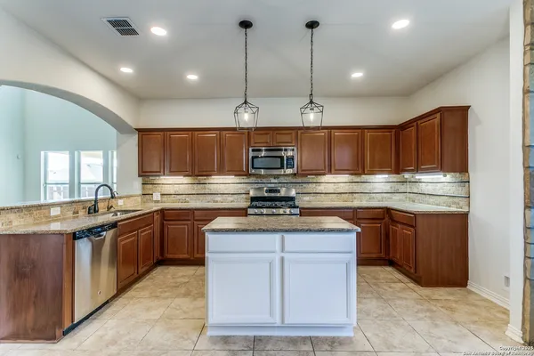 a kitchen with stainless steel appliances granite countertop a sink and stove