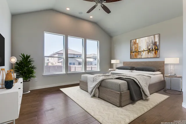 a spacious bedroom with a large bed and a potted plant