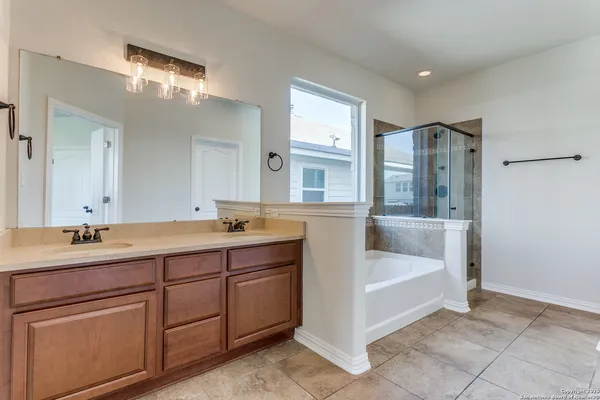 a spacious bathroom with a double vanity sink a mirror and a bathtub