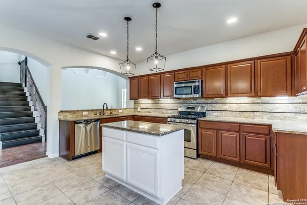 a kitchen with stainless steel appliances granite countertop wooden cabinets stove a sink and dishwasher