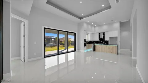a view of large kitchen with a sink and refrigerator