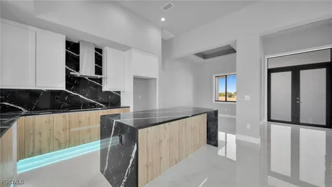 a kitchen with granite countertop a sink and white cabinets