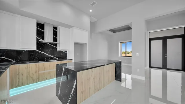 a kitchen with granite countertop a sink and white cabinets