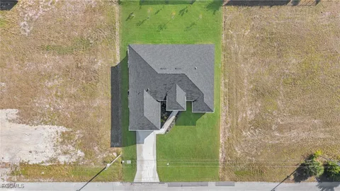 an aerial view of a house with a yard and lake view