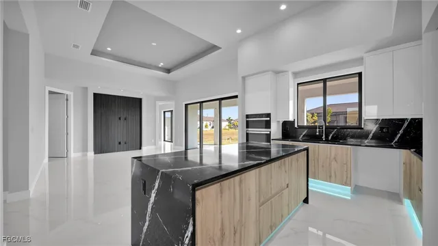 a kitchen with stainless steel appliances granite countertop a sink a stove and a refrigerator