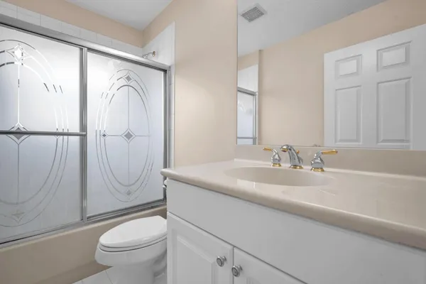 a bathroom with a sink a mirror a toilet and a shower
