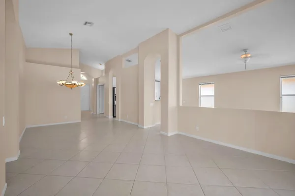 a view of a room with an empty space and a kitchen