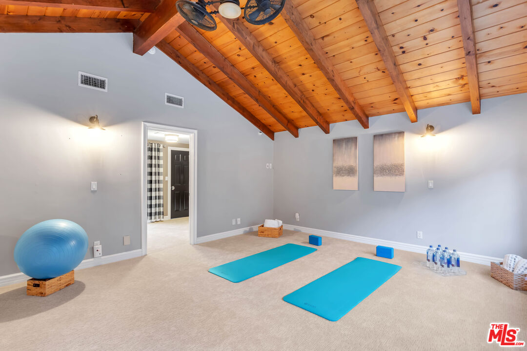 5488 Round Meadow Road Hidden Hills, CA 91302 - Photo 29 of 35 a bedroom with a bed and a chandelier