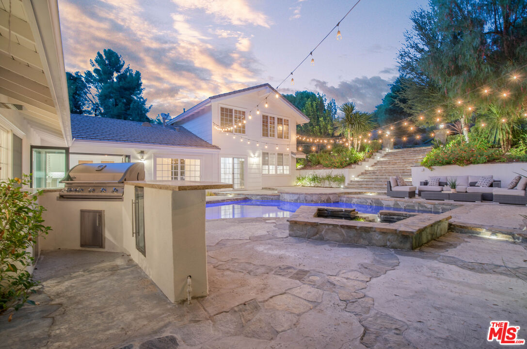 5488 Round Meadow Road Hidden Hills, CA 91302 - Photo 33 of 35 a view of a patio with table and chairs and potted plants