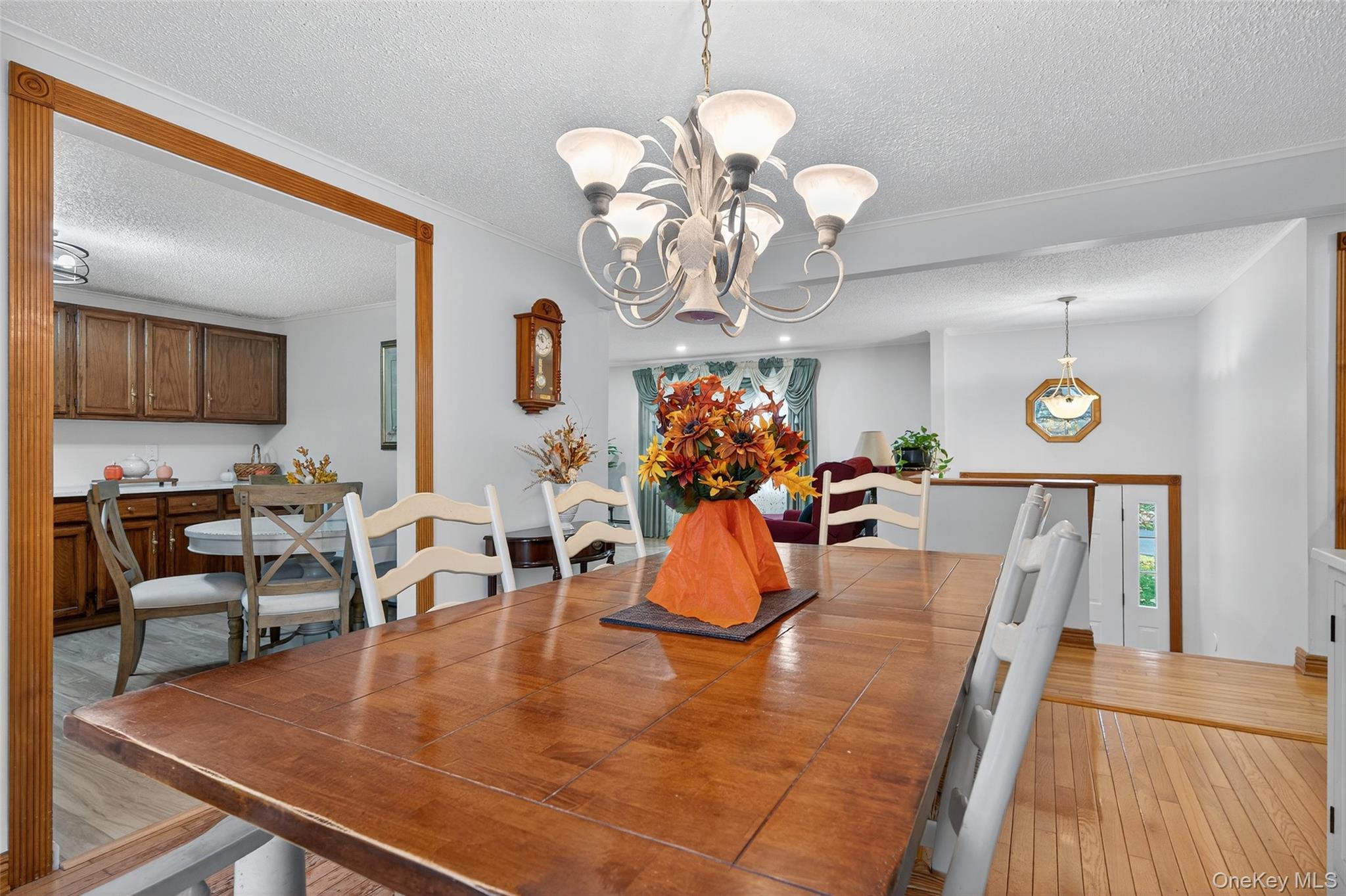 7 Colleen Lane Wallkill, NY 12589 - Photo 11 of 39 Dining space featuring light wood finished floors, a textured ceiling, a chandelier, and crown molding