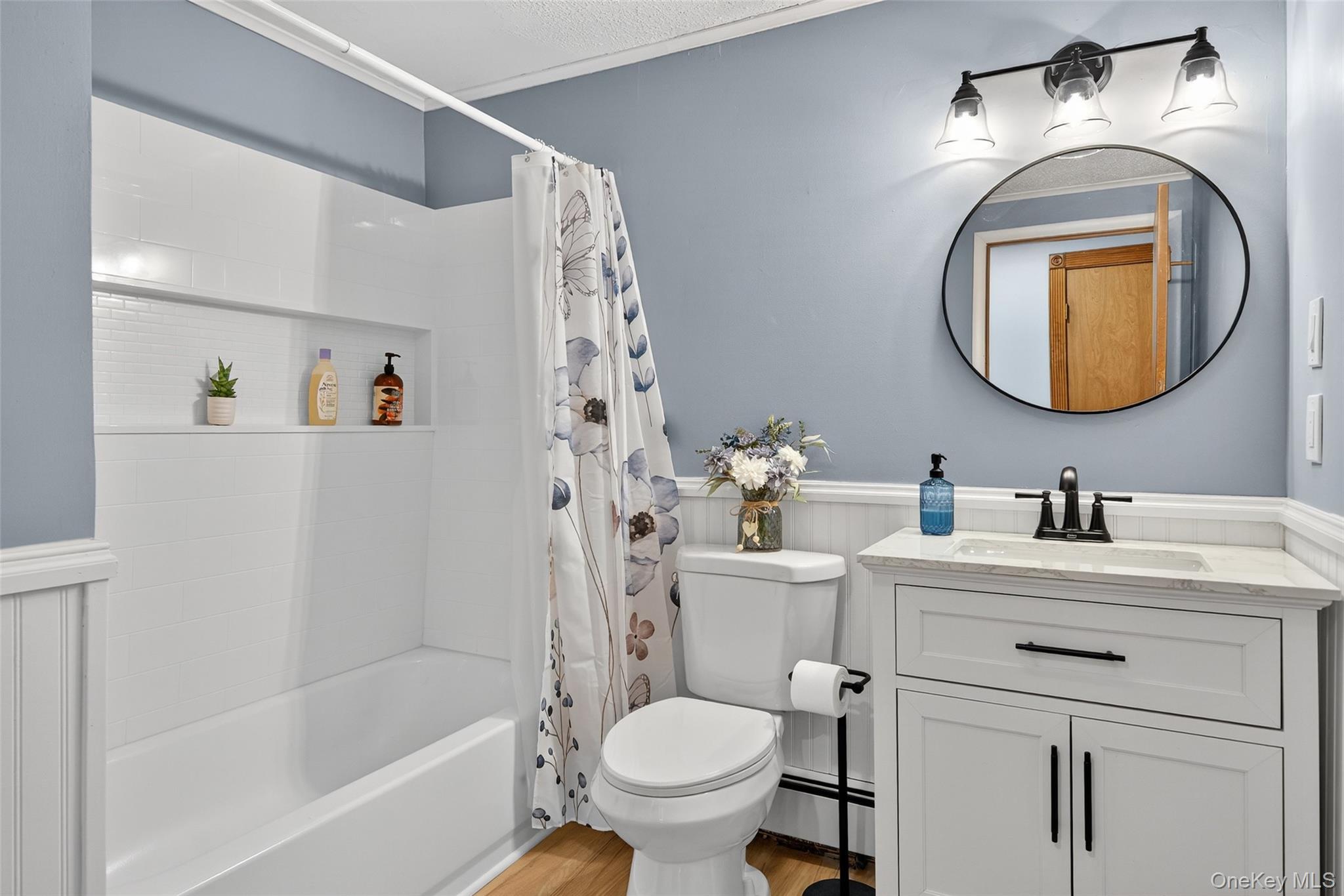7 Colleen Lane Wallkill, NY 12589 - Photo 20 of 39 Full bathroom with a wainscoted wall, vanity, shower / tub combo, a baseboard heating unit, and light wood-style floors