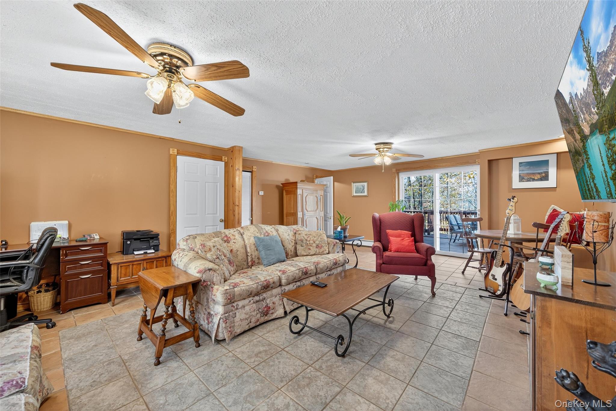 7 Colleen Lane Wallkill, NY 12589 - Photo 31 of 39 Living room featuring a desk, ceiling fan, a textured ceiling, light tile patterned floors, and crown molding