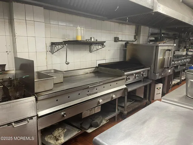 a living room with couches and kitchen view