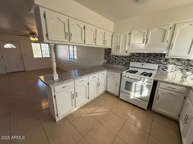 a kitchen with stainless steel appliances granite countertop a stove a sink and a microwave