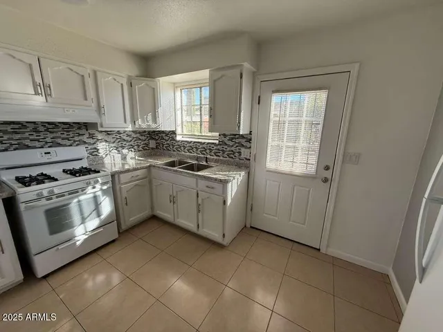 a kitchen with a stove sink and cabinets