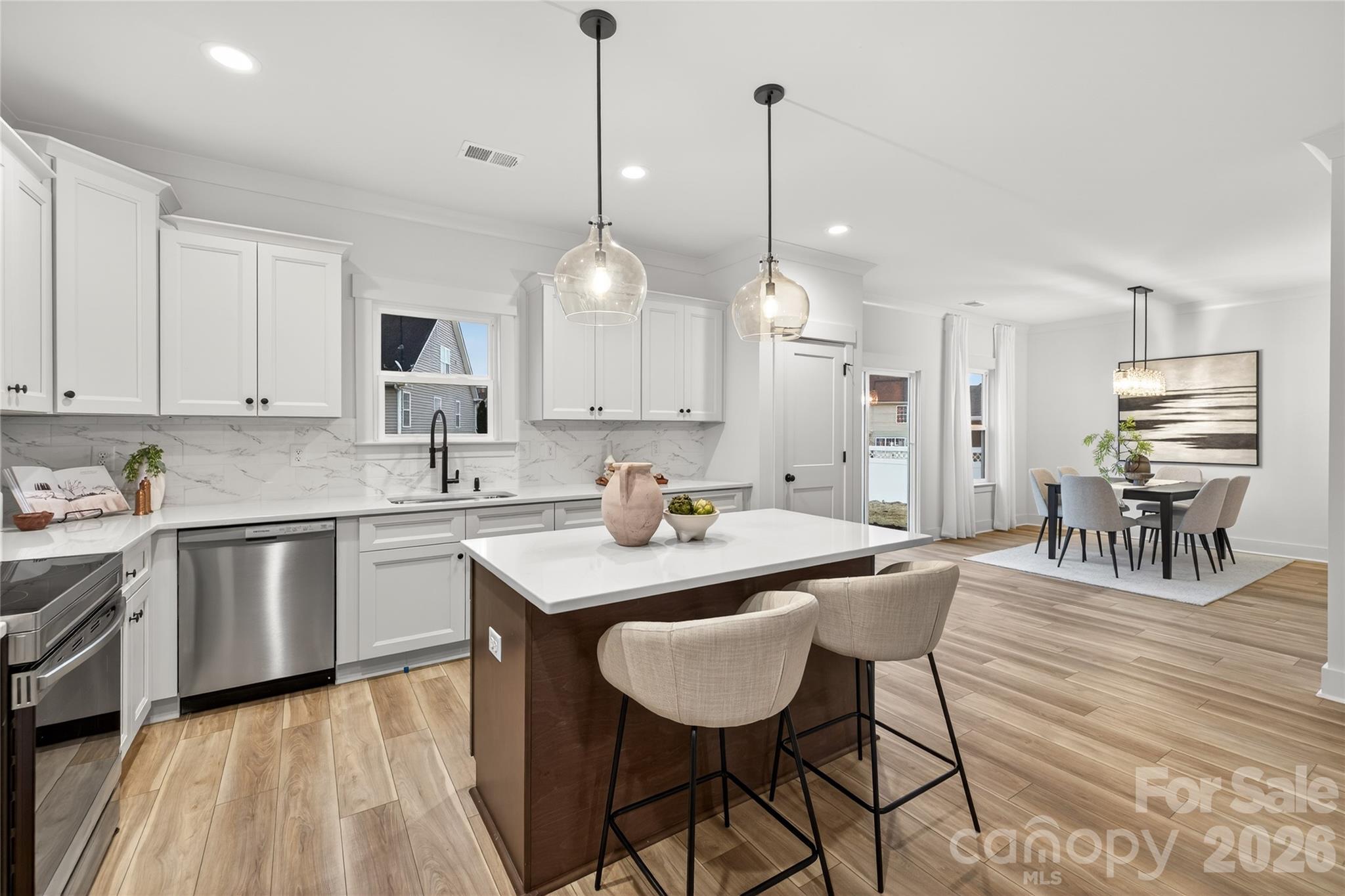 3388 Brackhill Street Davidson, NC 28036 - Photo 4 of 17 a kitchen with stainless steel appliances kitchen island granite countertop a sink a stove and chairs