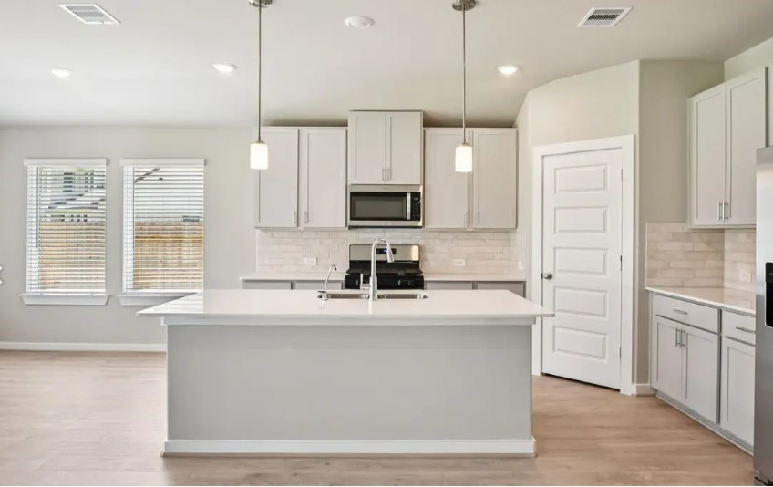 a kitchen with kitchen island white cabinets and stainless steel appliances