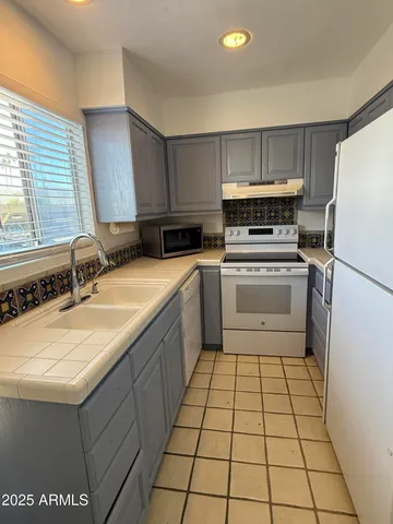 a kitchen with a sink a stove top oven a refrigerator and a sink