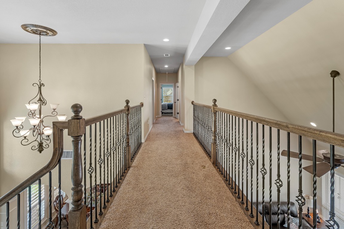 144 Indian Ridge Road Belton, TX 76513 - Photo 17 of 24 Hallway with recessed lighting, attic access, carpet floors, vaulted ceiling, and a chandelier