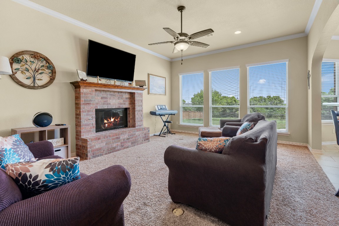 144 Indian Ridge Road Belton, TX 76513 - Photo 10 of 24 Living area with ornamental molding, a fireplace, light carpet, a ceiling fan, and recessed lighting