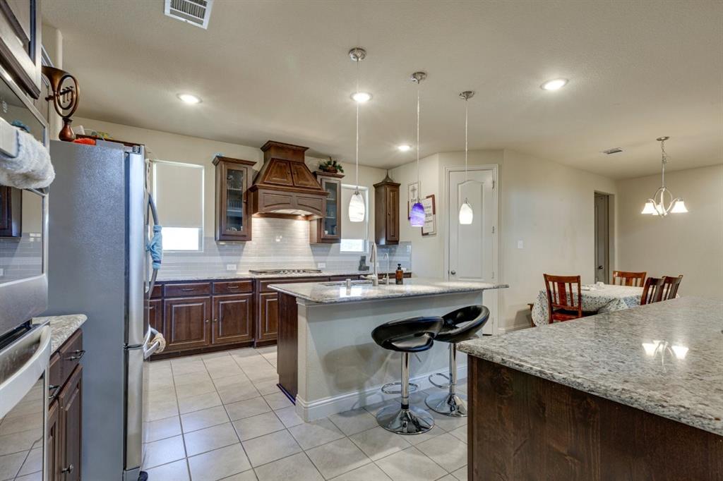 336 Red Hill Road Sunnyvale, TX 75182 - Photo 12 of 36 a kitchen with a sink a stove a refrigerator and chairs