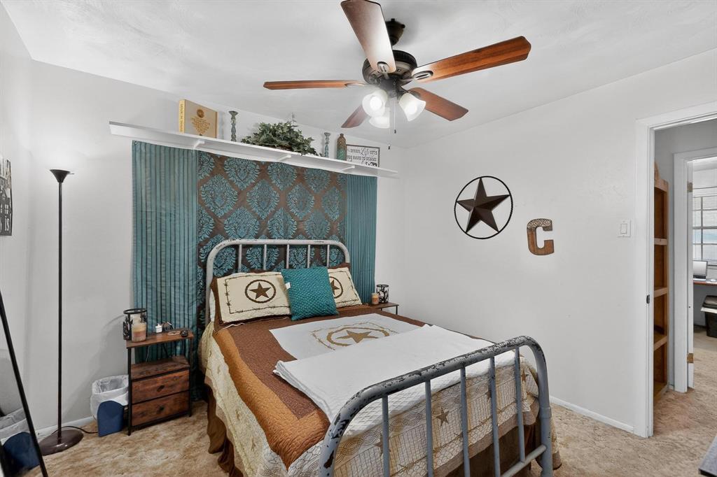 202 Senter Valley Road Irving, TX 75060 - Photo 24 of 32 Bedroom featuring a ceiling fan with light fixture, textured wall paneling, and an open doorway leading to another area