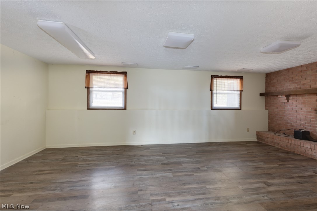9416 Kieffer Road Mantua, OH 44255 - Photo 18 of 29 Unfurnished living room featuring dark wood-style floors, a textured ceiling, and plenty of natural light