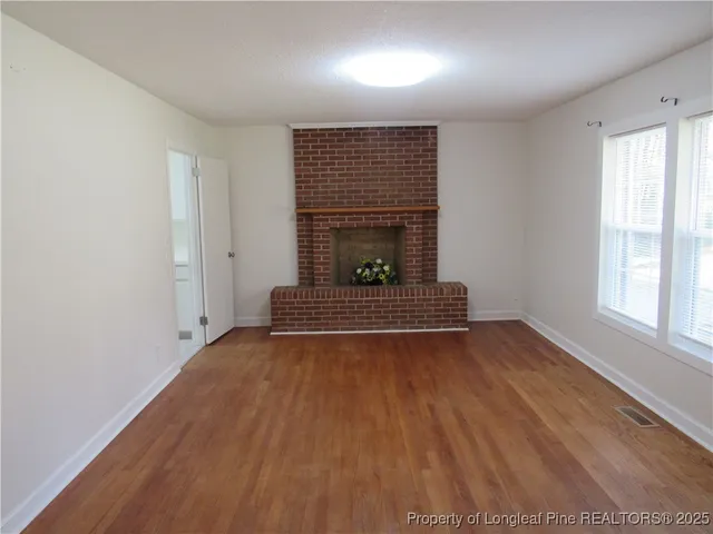 a view of a room with wooden floor and a fireplace