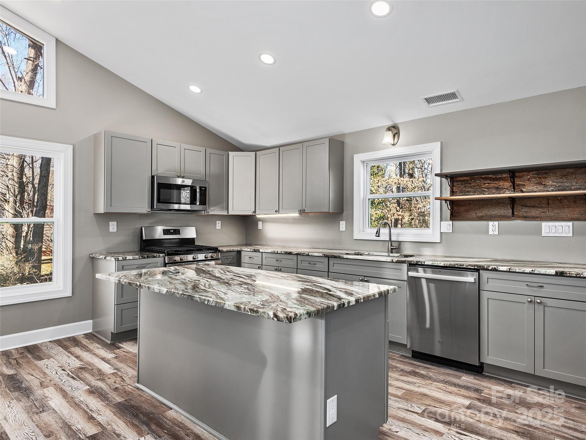 611 Peniel Road Columbus, NC 28722 - Photo 7 of 28 a kitchen with stainless steel appliances granite countertop a sink a stove a refrigerator cabinets and a window