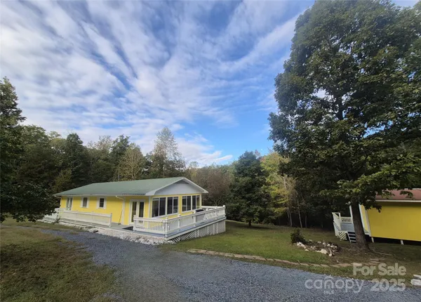 a view of a house with a yard balcony and tree