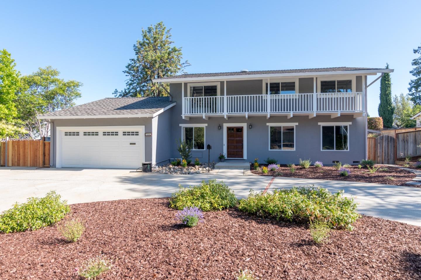 a front view of a house with garden and parking