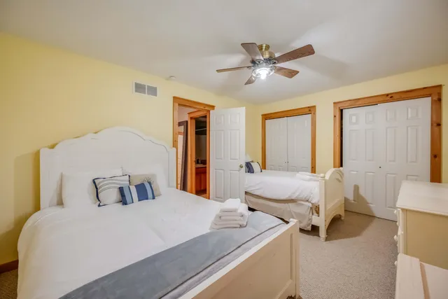 a bedroom with 2 bed and a chandelier