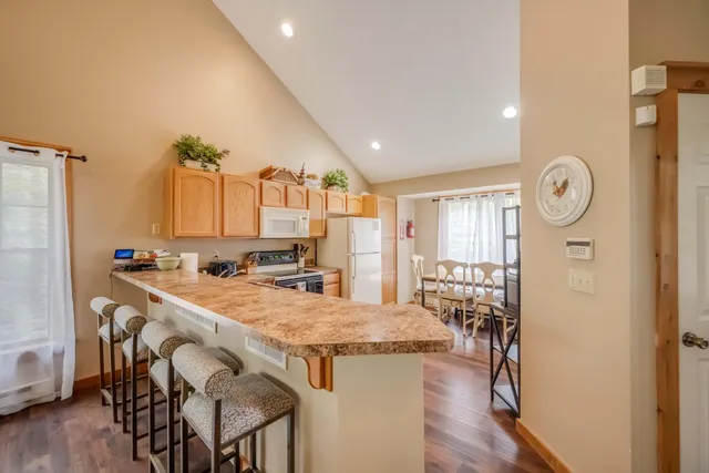 a kitchen with stainless steel appliances granite countertop a kitchen island a stove a table and chairs