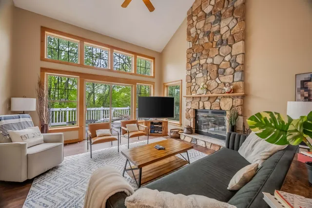 a living room with furniture a flat screen tv and a floor to ceiling window