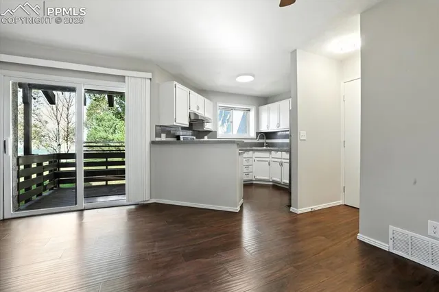 a view of a kitchen with wooden floor and a window