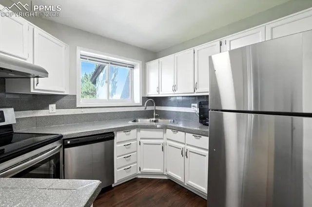 a kitchen with appliances a sink and a window