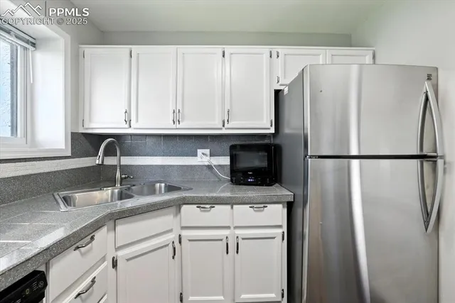 a kitchen with stainless steel appliances granite countertop a refrigerator sink and cabinets