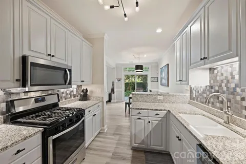a kitchen with stainless steel appliances granite countertop a sink stove and refrigerator