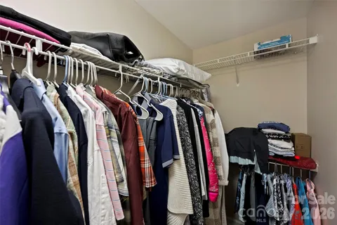 a view of walk in closet with clothes and shoes