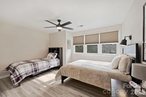 a bedroom with a bed wooden floor and window
