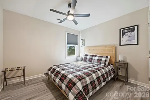 a bedroom with a bed wooden floor and window