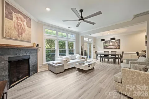a living room with furniture large window and wooden floor
