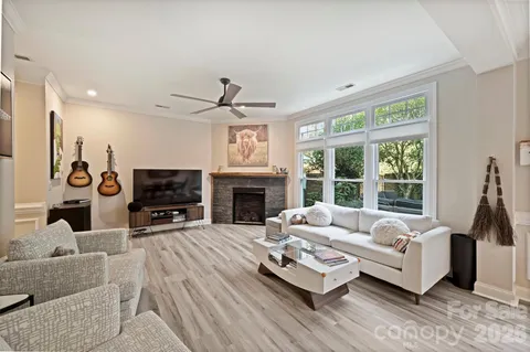 a living room with furniture fireplace and a large window