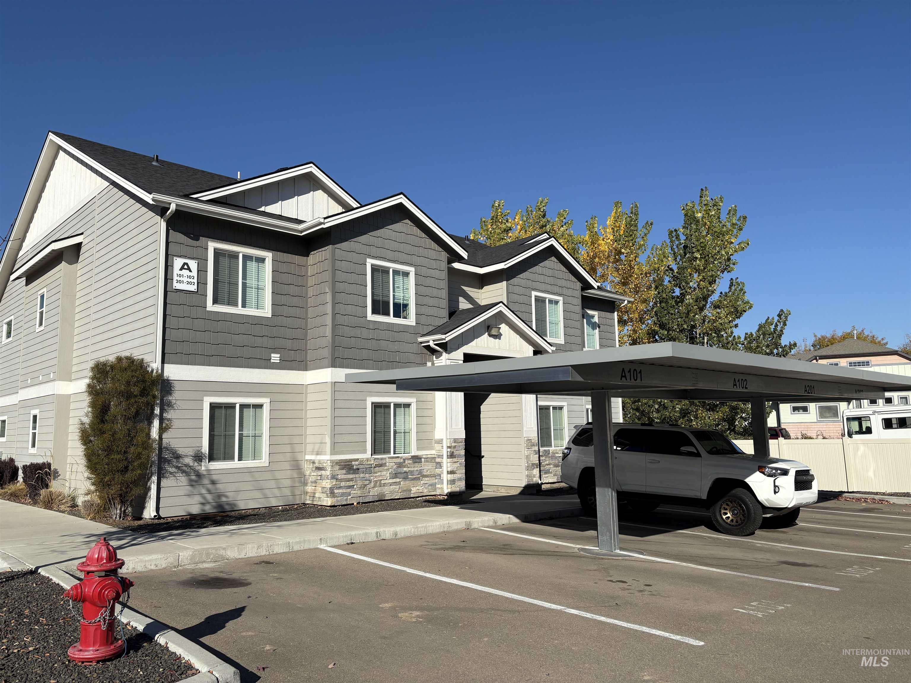 324 Northwest 3rd Street Meridian, ID 83642 - Photo 4 of 12 View of front of house featuring board and batten siding, covered parking, and stone siding