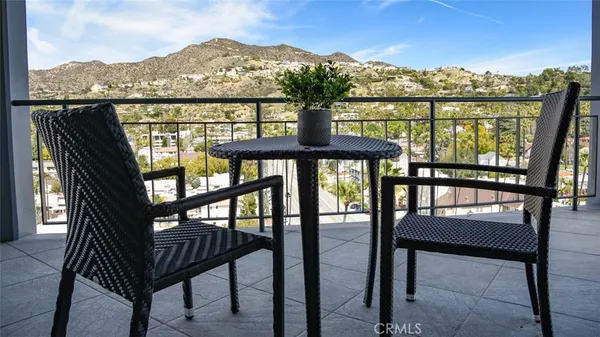 a view of a city from a balcony with furniture
