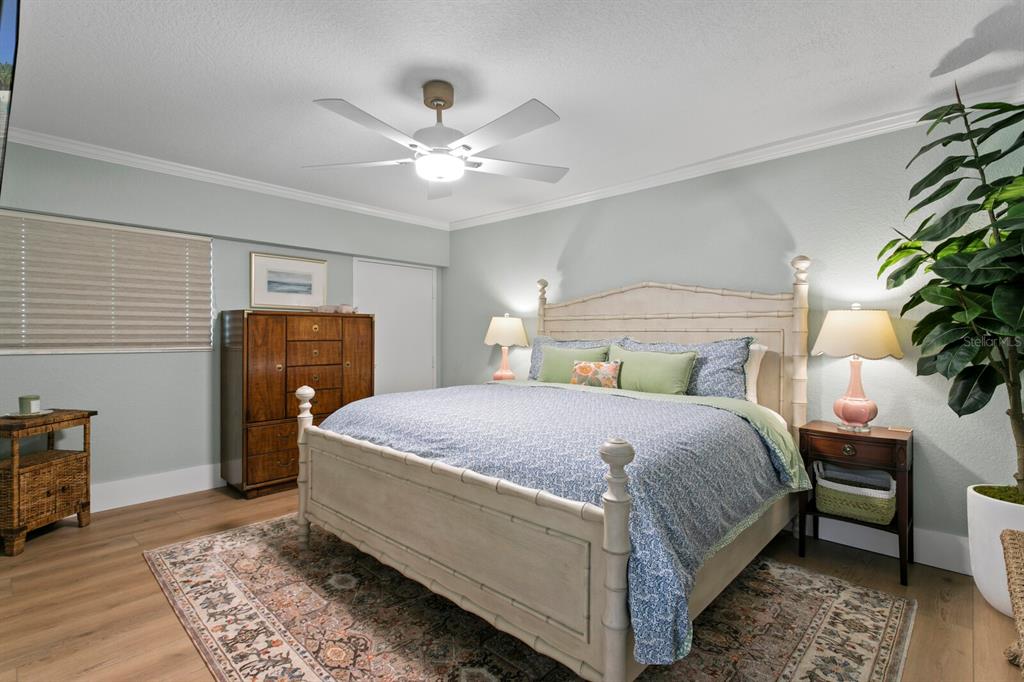 16332 Gulf Boulevard, Unit 3B Redington Beach, FL 33708 - Photo 35 of 91 a bedroom with a bed and a chandelier