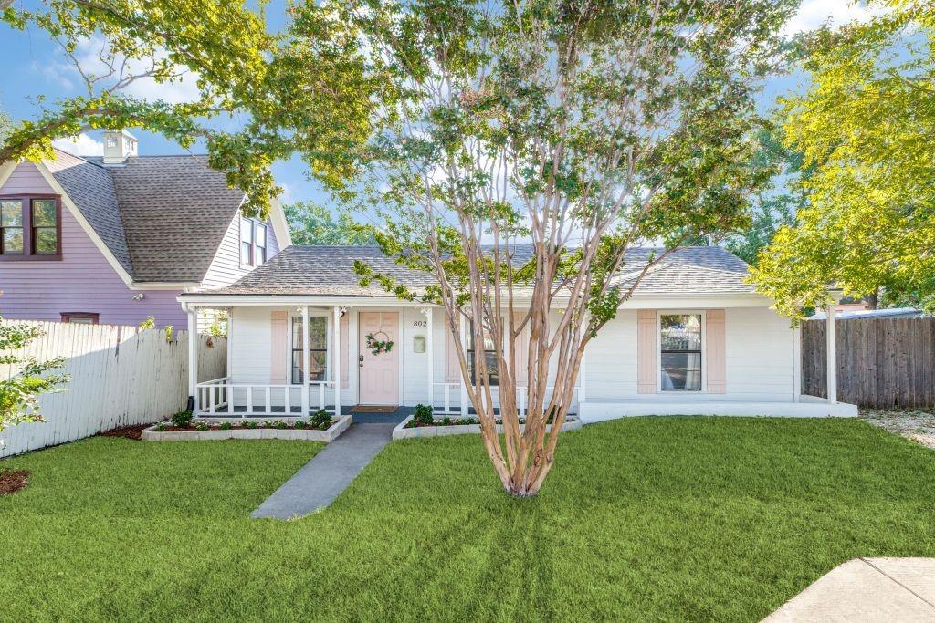 a front view of a house with a yard and trees