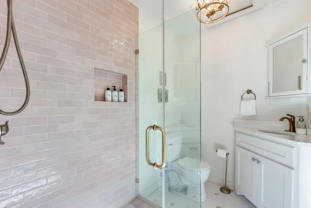 a bathroom with a granite countertop toilet sink and mirror